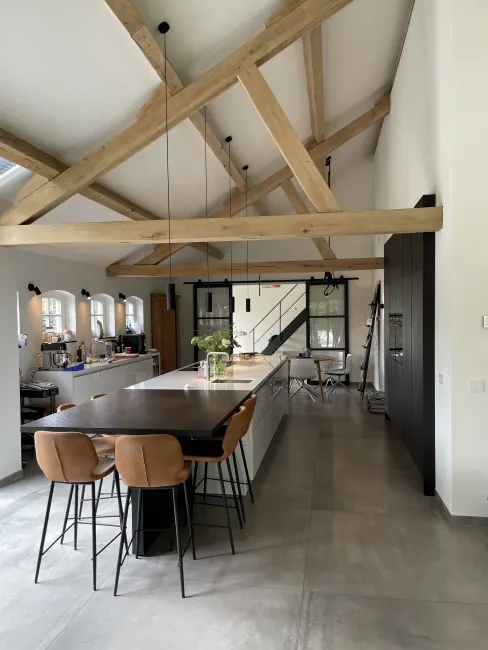 Keuken met hanglampen onder houten spanten in Berlicum
