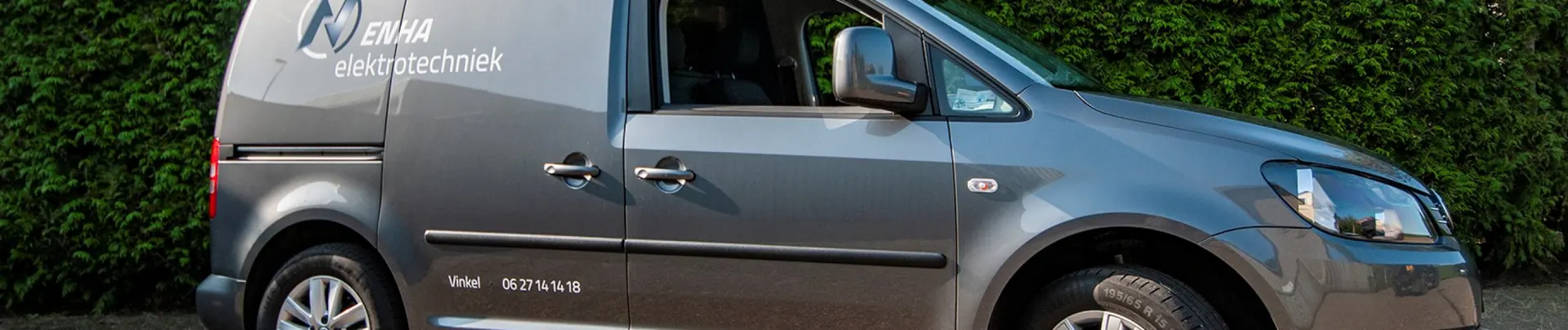 De bedrijfsbus van ENHA Elektrotechniek met logo en telefoonnummer