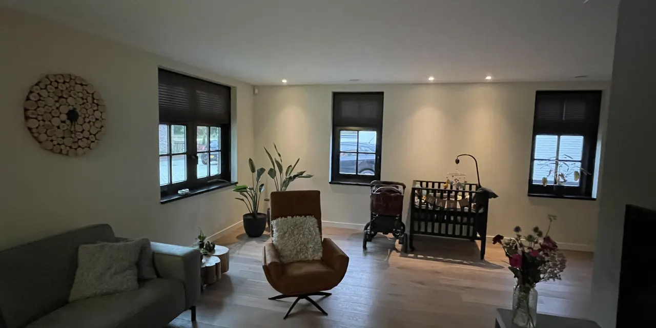 Lichte woonkamer met inbouwspots in een nieuwbouwwoning in Nuland